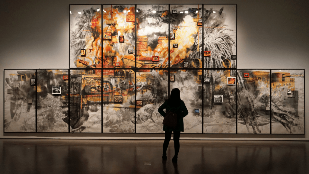 A person standing in front of a large painting