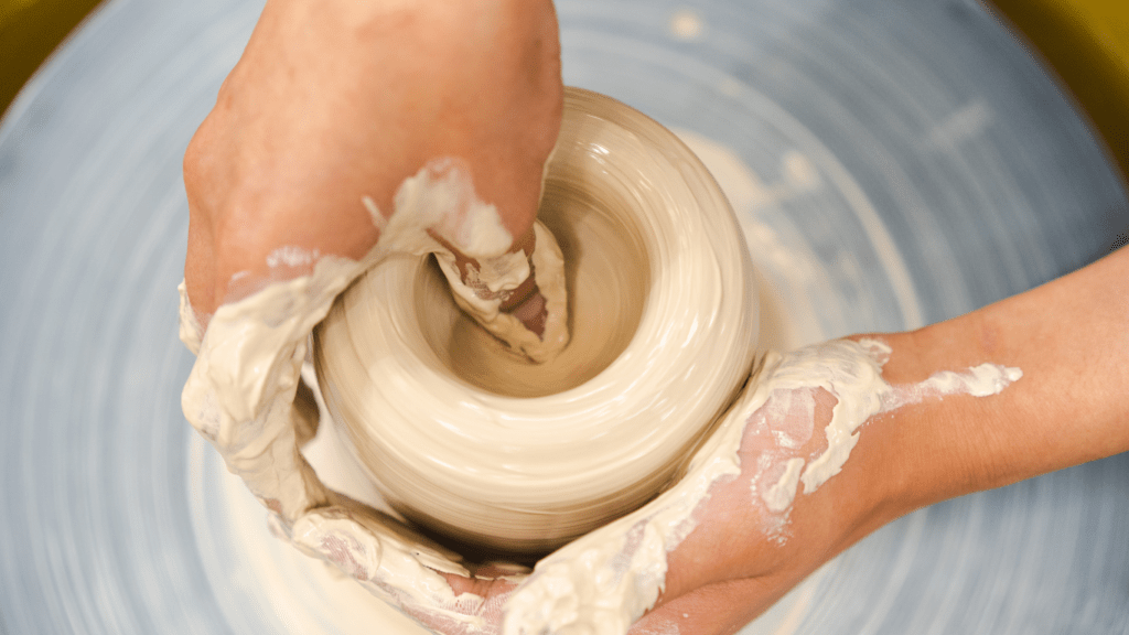 a person is making a pot on a potter's wheel