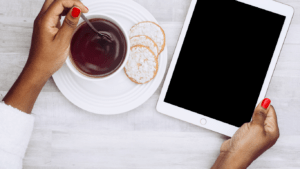 top view of hands holding an ipad on a wooden table