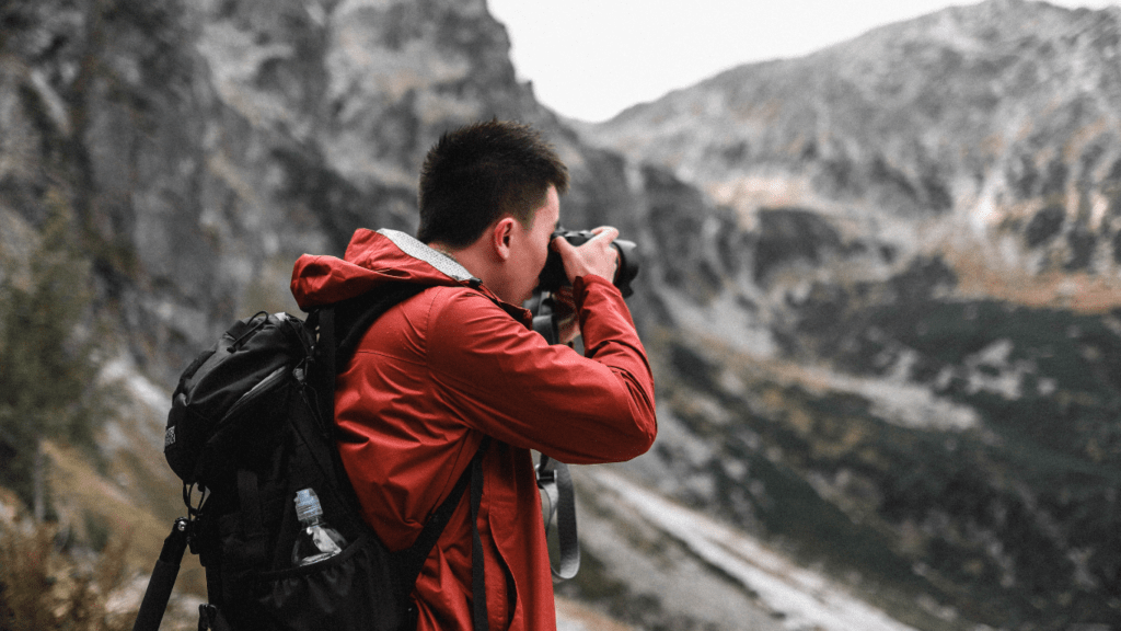 a person with a backpack is taking a picture of the mountains