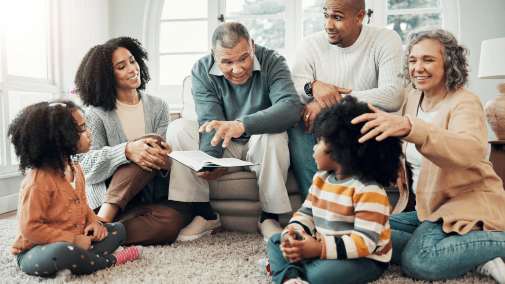 A family sitting on the floor looking at a book