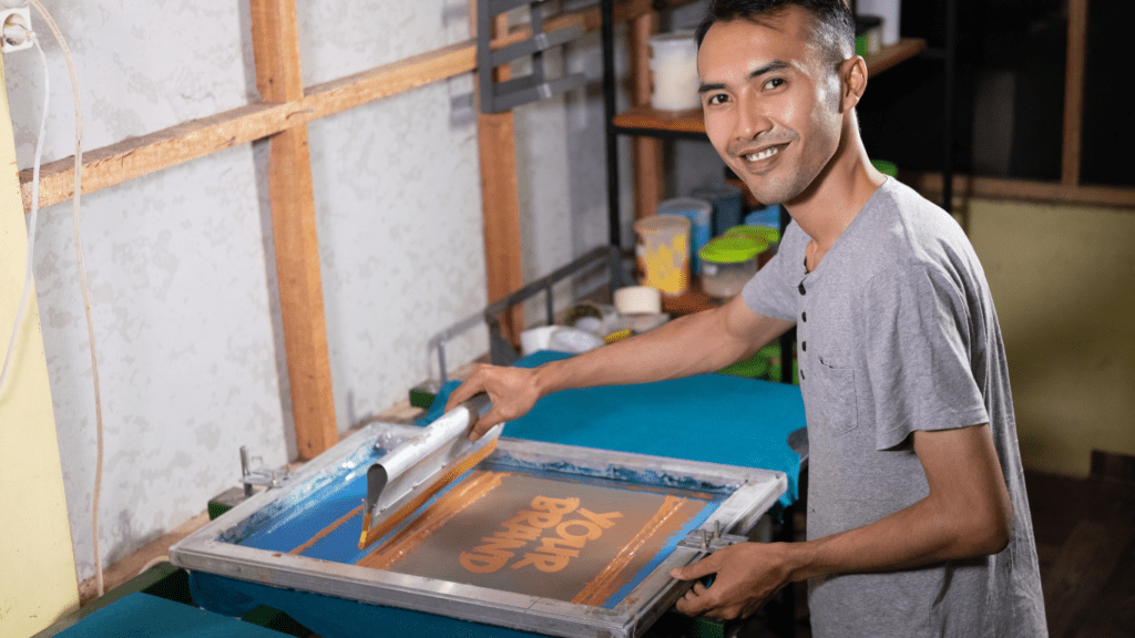 a person is working on a screen printing machine