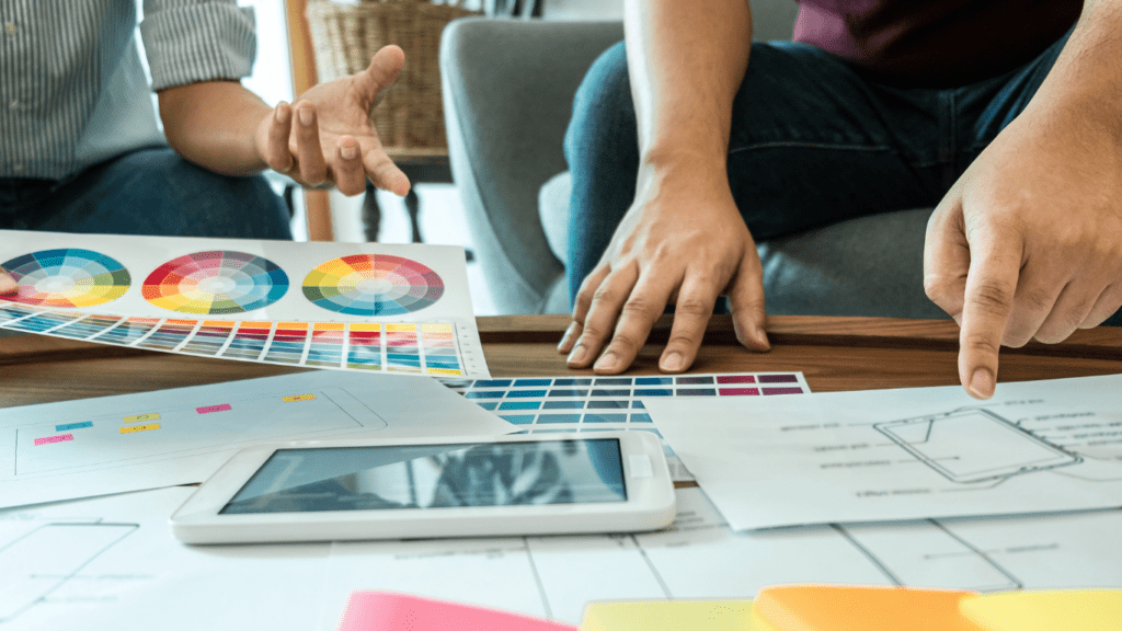 a group of people sitting around a table with colorful papers