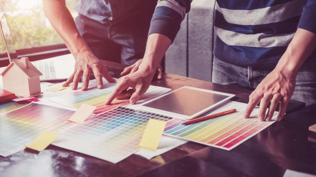 a group of people sitting around a table with colorful papers