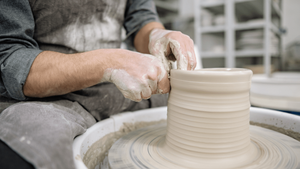 a person is making a pot on a potter's wheel