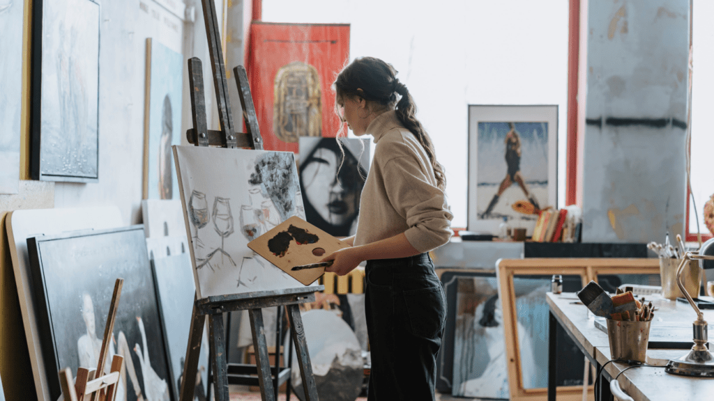 a person is painting on an easel in an art studio