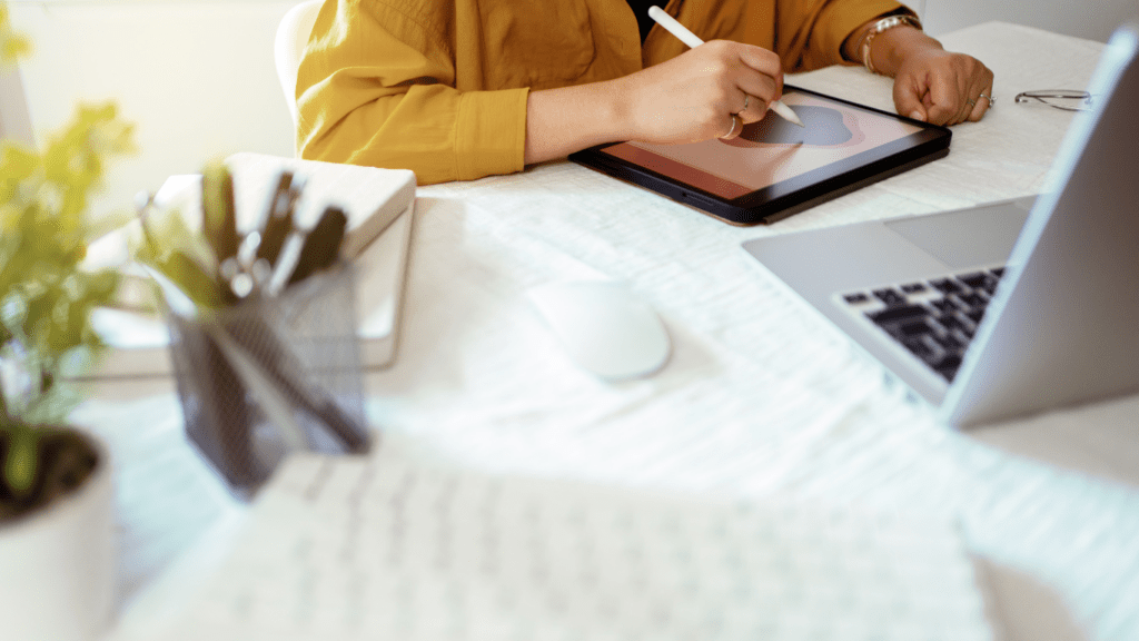 a person is sitting at a table with a laptop and a notebook