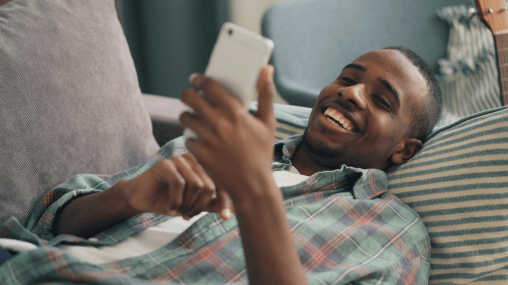 a person is smiling while using a cell phone