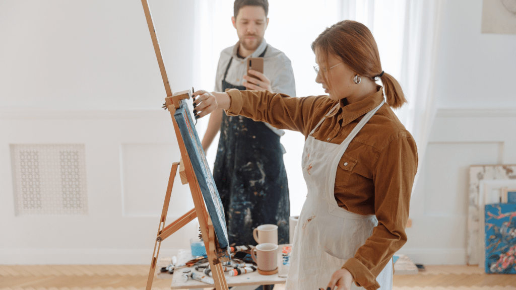 a person is taking a picture of a painting on an easel