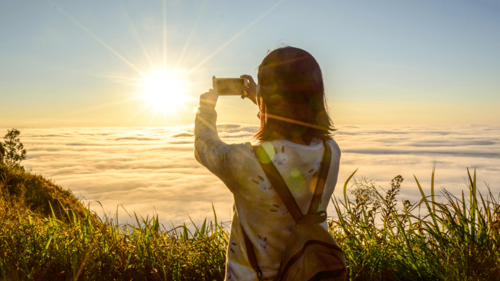 a person with a backpack is taking a picture of the mountains